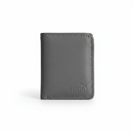 A person holding a dark gray Puma bifold wallet against their navy blue polo shirt.