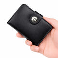 Black leather wallet held in a hand against a white background
