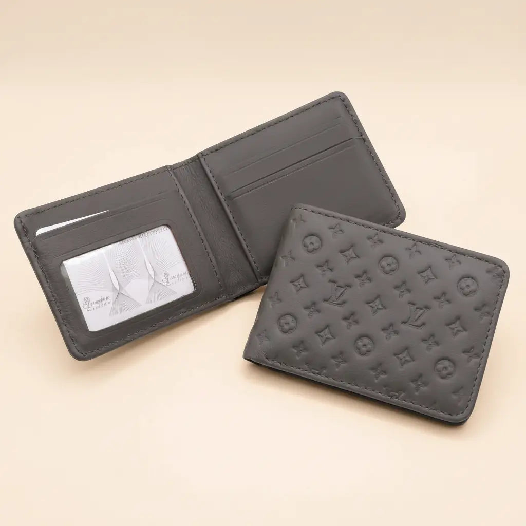 Two dark gray leather bifold wallets shown on a warm beige background. One wallet is open, displaying card slots and a clear ID window with a card inside.